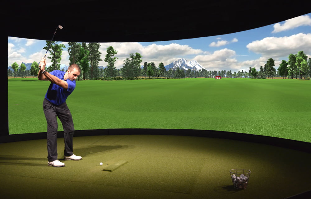 A golfer swinging in a simulator