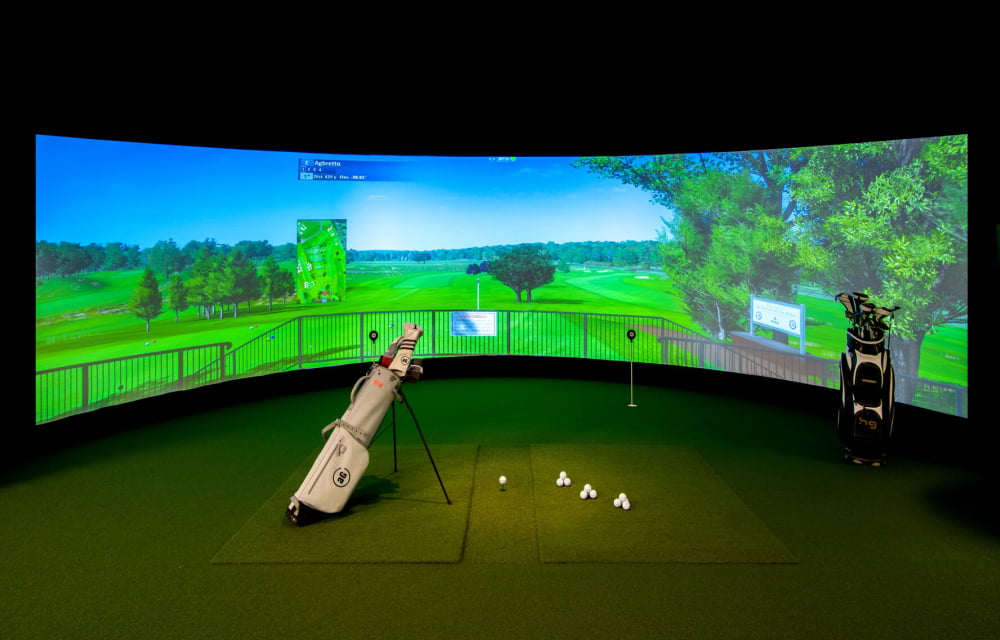 A golf simulator with a curved screen