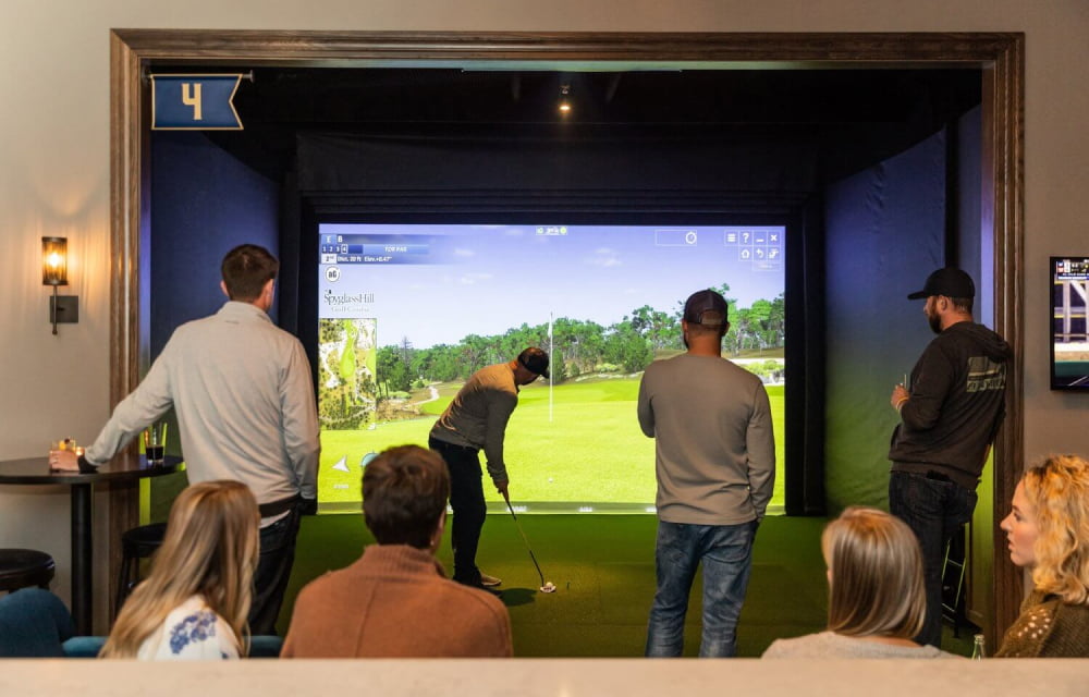 A group of people in a golf simulator